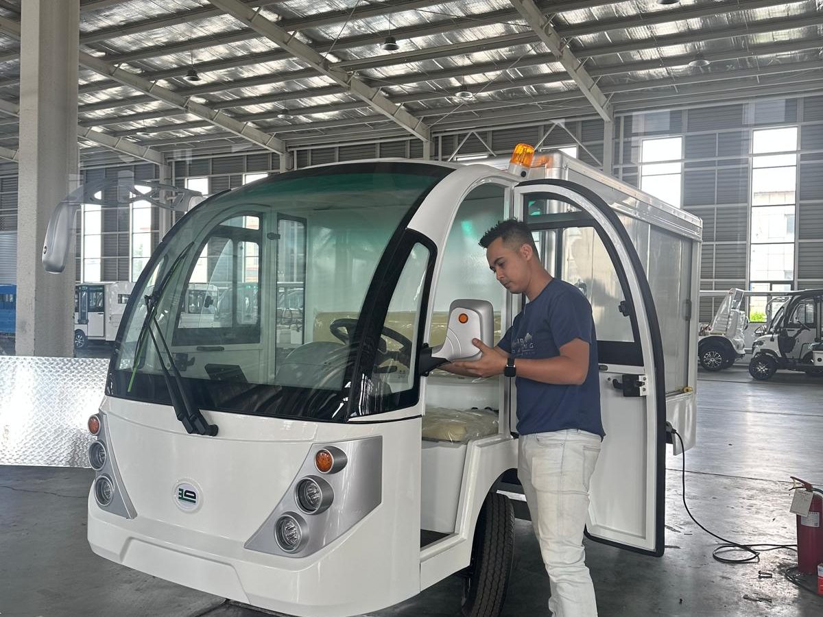 Engineer performing quality inspection on a custom electric cargo buggy before shipment to Singapore.